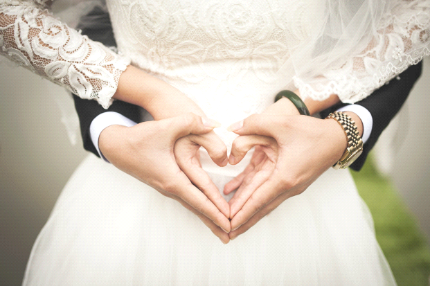 A married couple form hands in the shape of a heart. Wedding Event Insurance, Wedding Insurance.